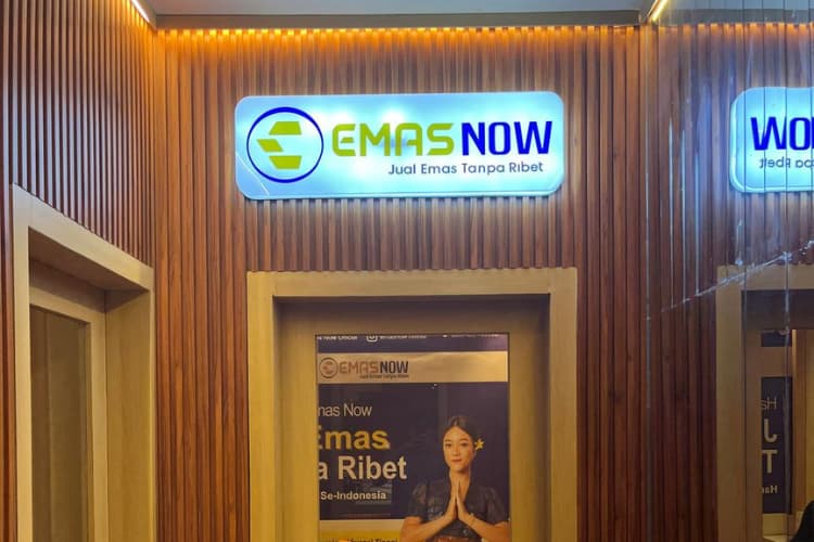 Tampilan depan outlet Emas Now dengan logo bercahaya dan slogan “Jual Emas Tanpa Ribet”, dilengkapi poster pelayanan ramah oleh staf wanita berbusana tradisional di dalam ruangan bernuansa kayu.
